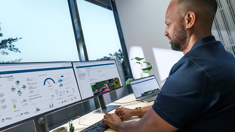 Techniker überprüft Photovoltaikanlage auf einem Hausdach, SMA Logo im Vordergrund – Symbol für Service und Garantie